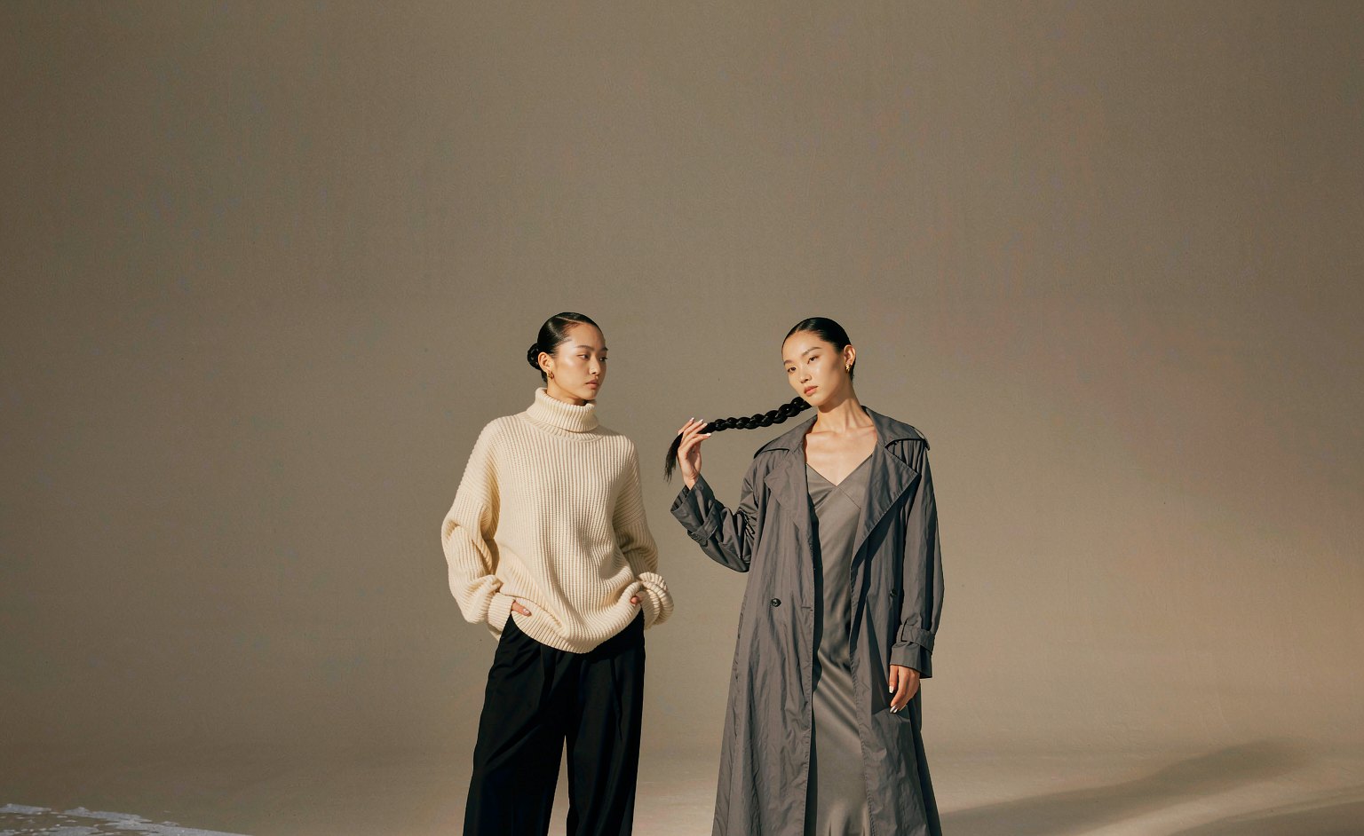 Two models wearing Pre-Fall 26 knitwear and outerwear